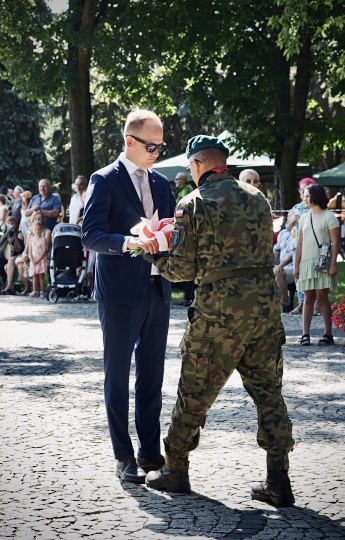 Radny Paweł Wnukowski składa wiązankę kwiatów pod pomnikiem